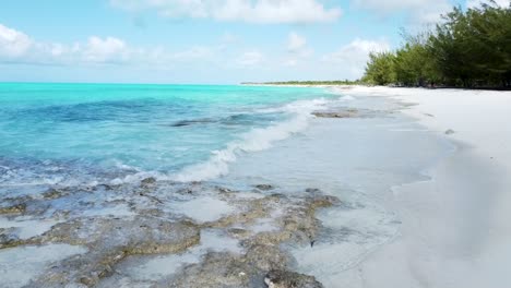 Luftaufnahme-Entlang-Eines-Weißen-Strandes-Weiter-Draußen-über-Dem-Türkisblauen-Meer