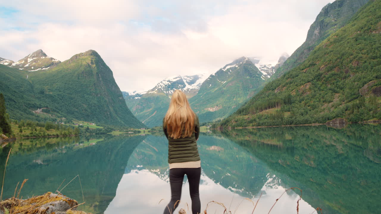 Woman with outstretched arms enjoying the Norwegian fjord