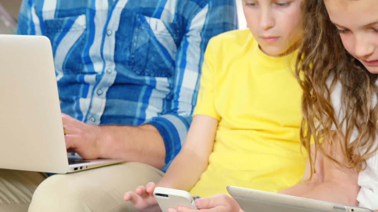 familia usando dispositivos en el sofá