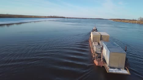 river transport with barge and tugboat in winter