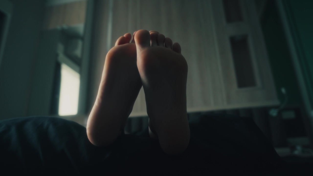 Persona che si rilassa e muove le dita dei piedi a letto