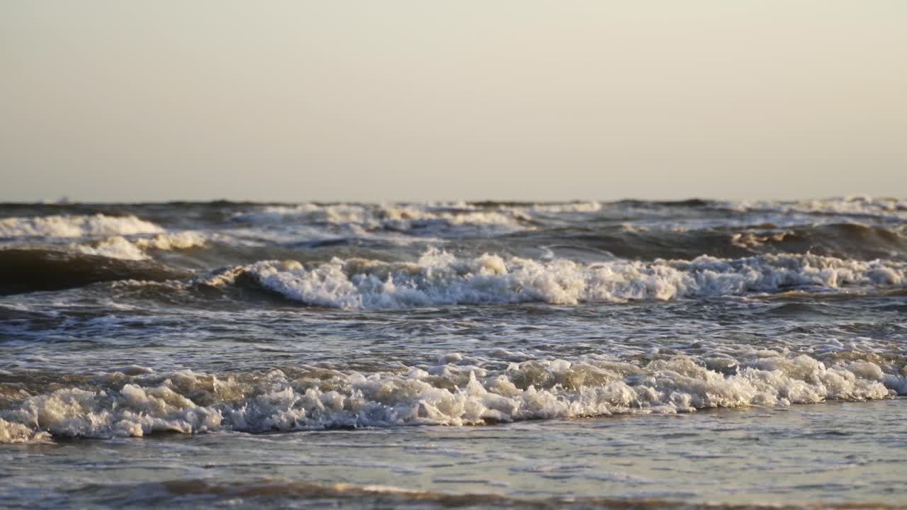 Storm in the sea. Big foamy waves crashing on the beach. Oceanic background at the edge of a coastline. Close-up.