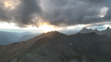 Volando-Sobre-La-Cresta-De-Una-Montaña-Y-Descubriendo-Un-Camino-En-Un-Valle-De-Los-Alpes-Franceses