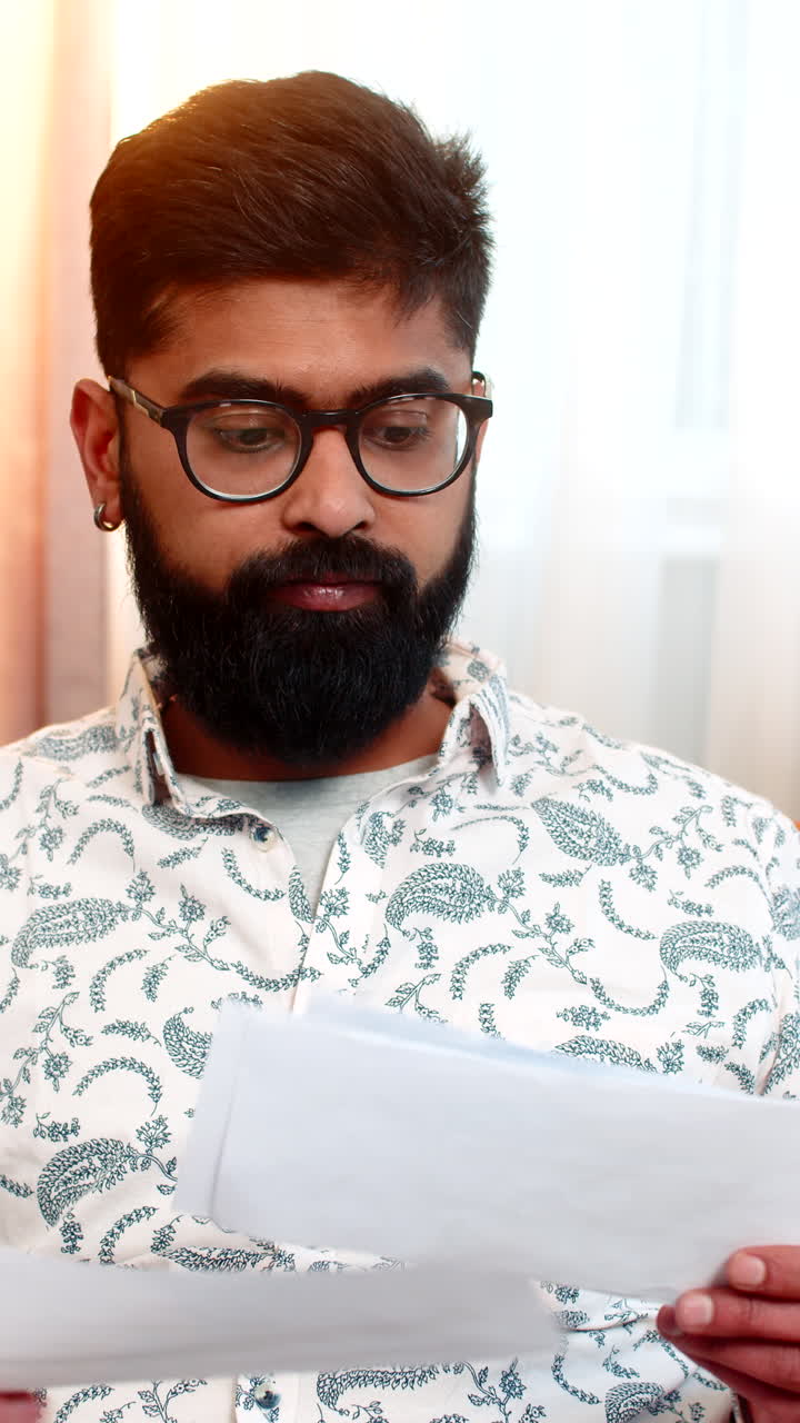 Man shocked while reading utility bills at home sad stressed about rising prices debt and bankruptcy