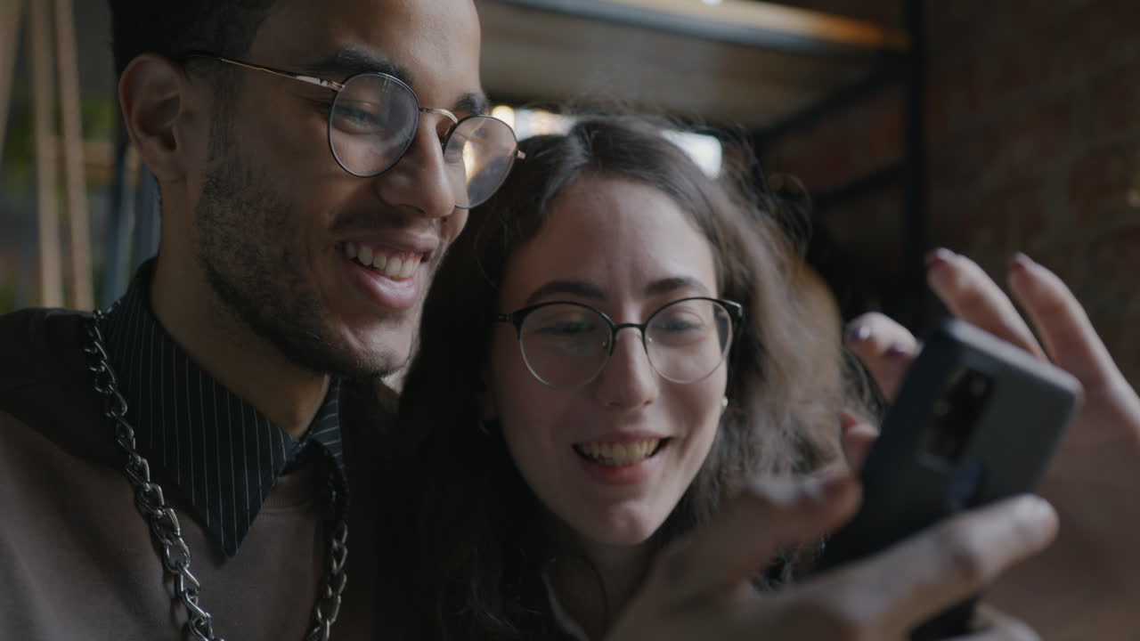 Couple Looking at a Smartphone in a Cafe