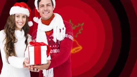 Animation-of-happy-couple-holding-christmas-present-over-holly-and-bells-on-red-circles