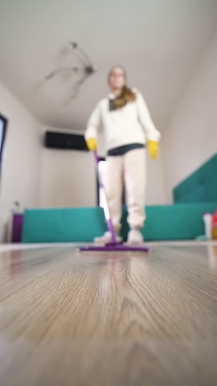 Førstepersonsperspektiv av en kvinne som vasker gulvet hjemme, som viser hjemmeliv, hygiene og daglig husholdningsrengjøringsrutine.