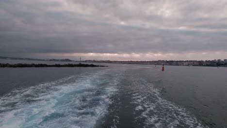 Arriving-to-Pedrena-port-in-Santander-bay-view-from-a-ferry-boat-during-sunset-cloudy-summer-day