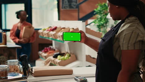 vendedor afroamericano que utiliza una plantilla de pantalla verde en el mostrador