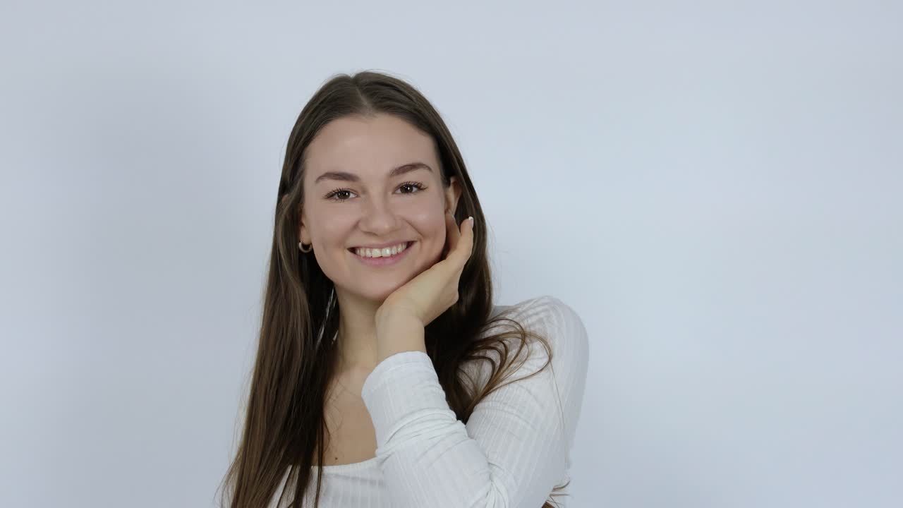 feliz y hermosa joven morena posando frente al fondo blanco maquillaje, retrato de sonrisa