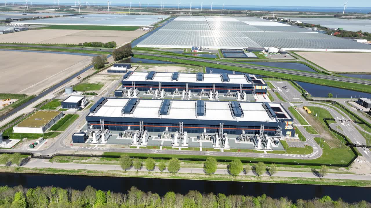 data center, server space, computing center, big tech, big data, industrial data processing, building exterior. Middenmeer, The Netherlands. Aerial video.