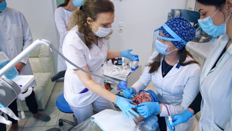 dentistry teacher talking to the student sitting near the patient. practical lessons for future orthodontists. top view.