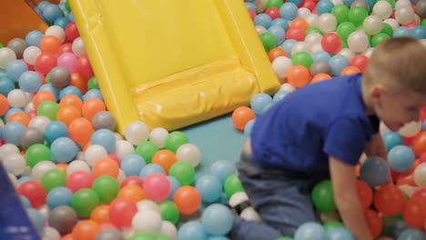 dynamic shot of a little boy joyfully whooping as he speeds down a colorful slide