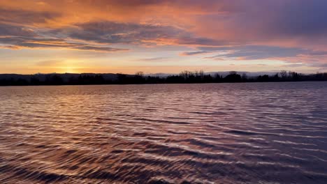 the sun sets on the columbia river, casting vibrant colors across the sky and reflecting off the water, creating a breathtaking and tranquil evening scene