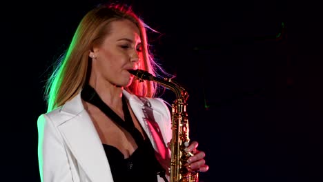 woman playing saxophone on stage