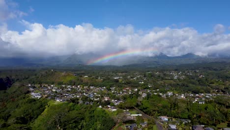 excelentes imágenes aéreas de un arco iris que abarca un campo en kauai.