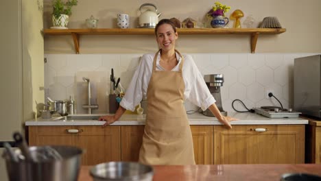 smiling woman in kitchen wearing apron