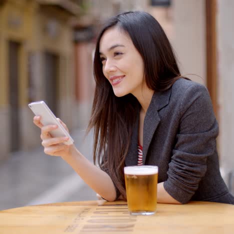 一位微笑的年轻女人正在喝啤酒放松