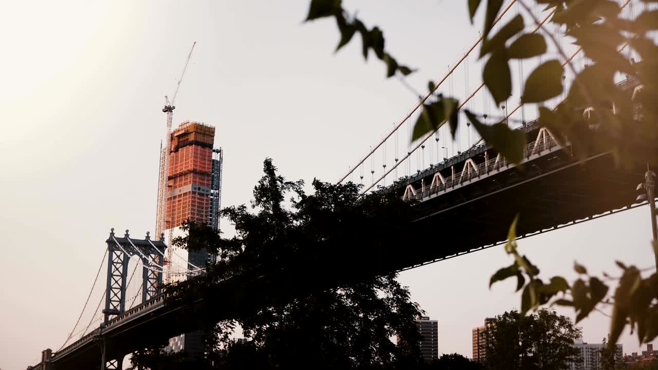 뉴욕의 맨해튼 다리의 아름다운 낮은 각도 전망, 배경 4k에서 건설 중인 나무와 마천루