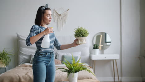 woman spraying plants in bedroom