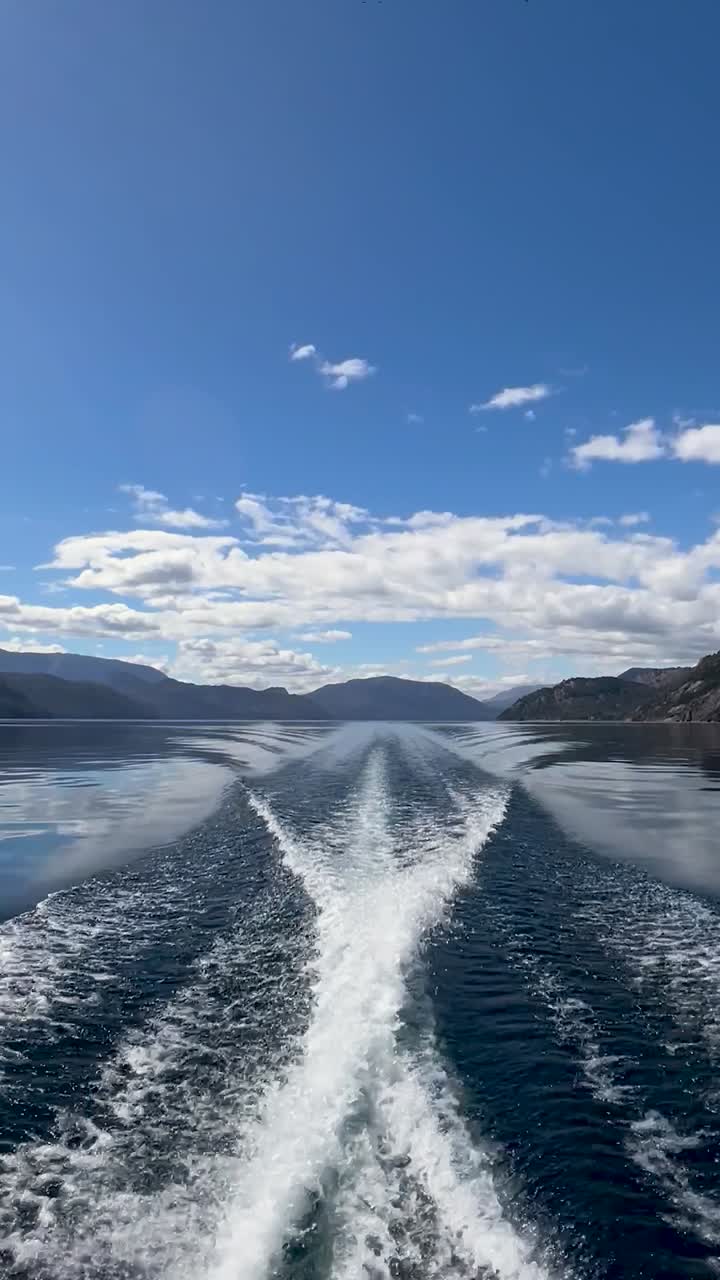 A boat leaving a wake behind on the calm waters of Lago Lacar Quila Quina, Argentina