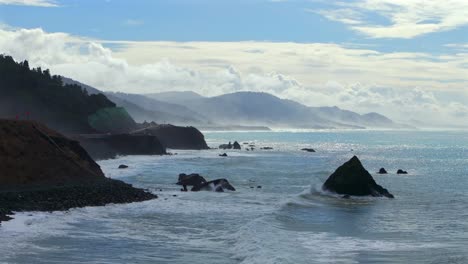 shoreline pacific coastal highway 1 dehaven westport fort bragg aerial drone california rugged coastline blue sky surf waves crashing boulder rocks mountain side clouds sun pacific ocean up motion