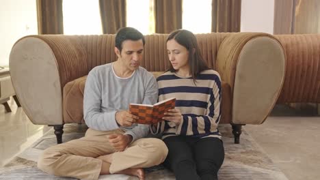 indian couple reading and discussing a book