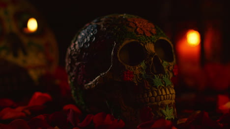 still life of decorated skull surrounded by candles and flower petals celebrating mexican holiday of dia de muertos or day of the dead 1