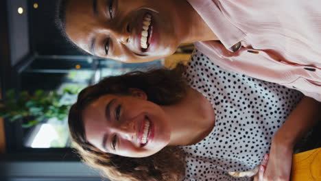 Vertical-Video-Of-Two-Young-Female-Friends-Meeting-In-Coffee-Shop-And-Posing-For-Selfie