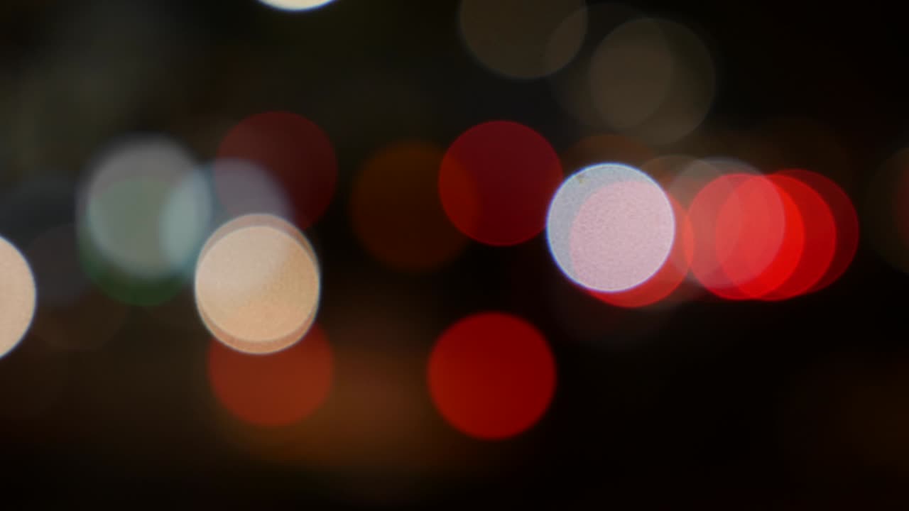 hermoso bokeh brillante en el fondo oscuro borroso por la noche. el redondo bokeh colorido brilla de las luces de los coches en la calle de la ciudad. fuera de foco con borroso. luces de la ciudad sin enfoque. bokeh de tráfico. concepto abstracto