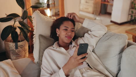woman relaxing on couch and using phone