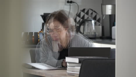 caucasian woman studying in the kitchen with tenacity