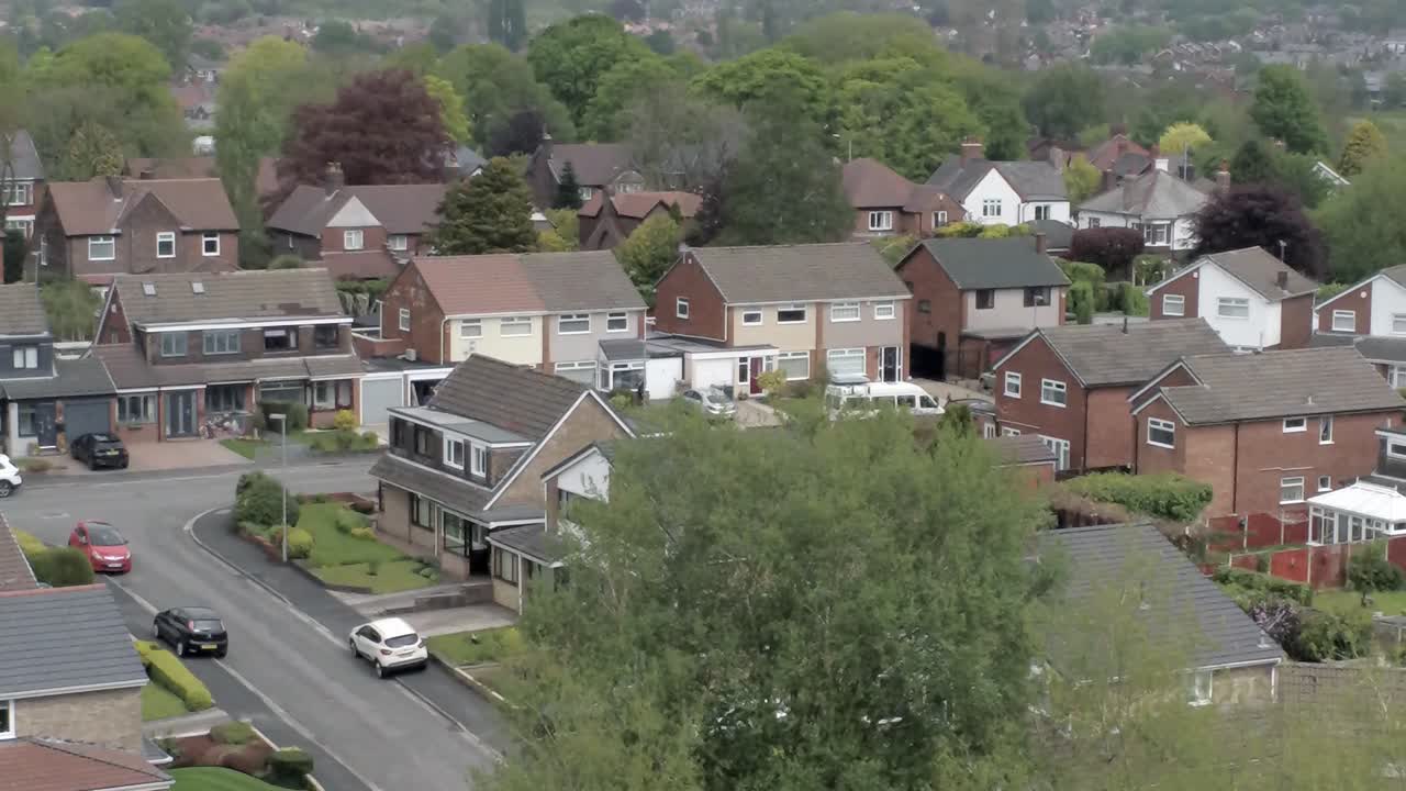 Quiet British homes streets and gardens residential suburban property aerial view zoom out