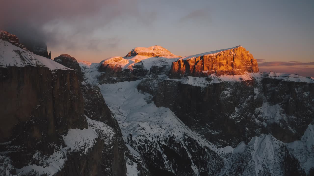 Golden light at sunset on the snowy Sass Pordoi and Piz Boè