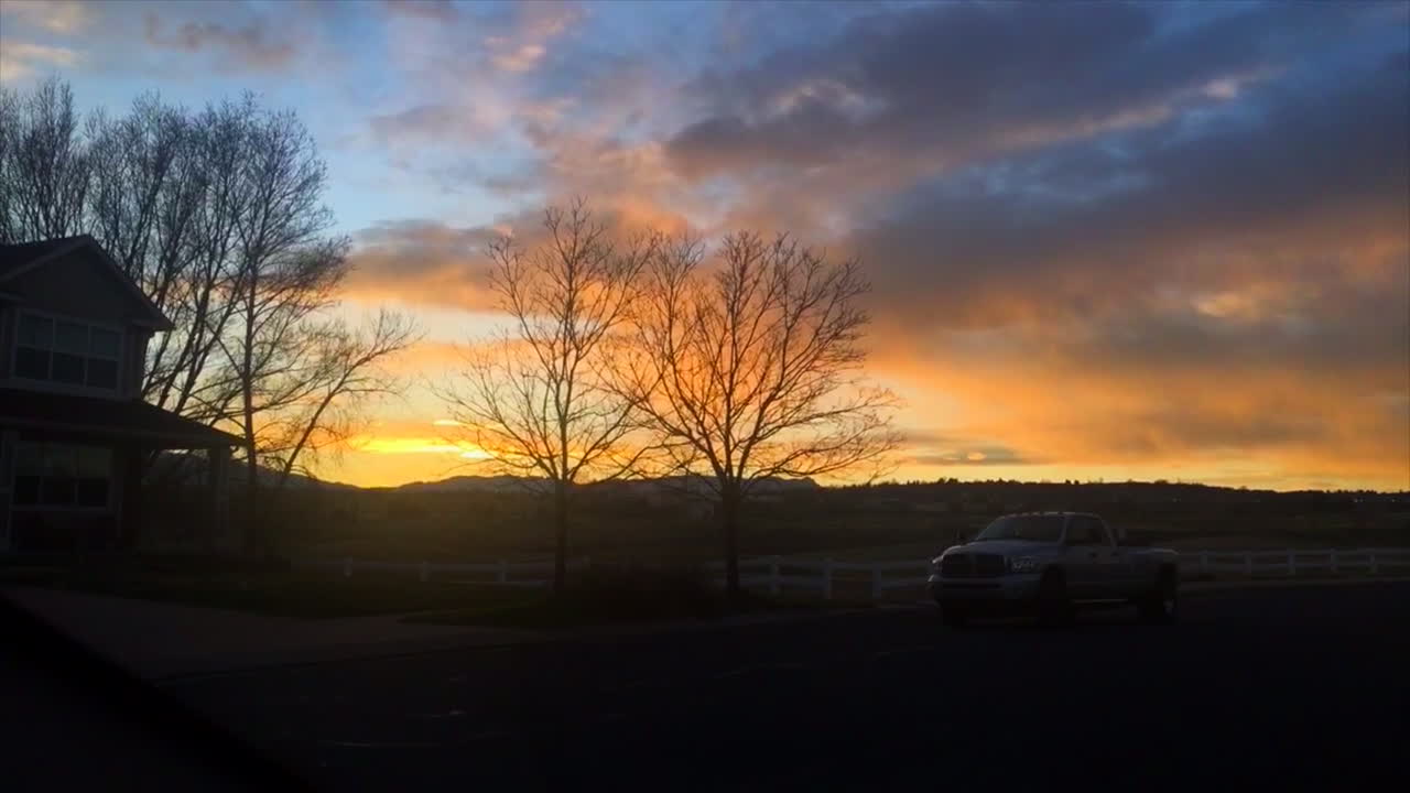 Colorado sunset in a neighborhood with a truck driving by.