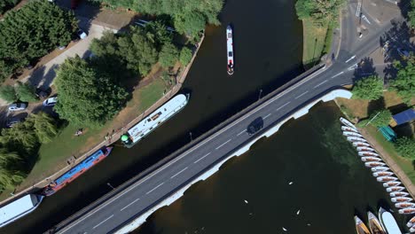 Aerial-view-tracking-vehicle-driving-over-Clapton-historical-archway-canal-bridge,-England