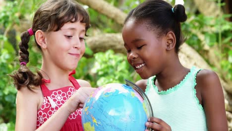 schoolkids looking at globe in campus at school