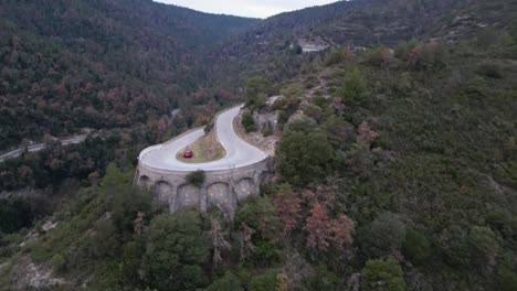 Red-car-stranded-on-dangerous-curve-between-Vinyoles-and-Sobremunt,-Barcelona