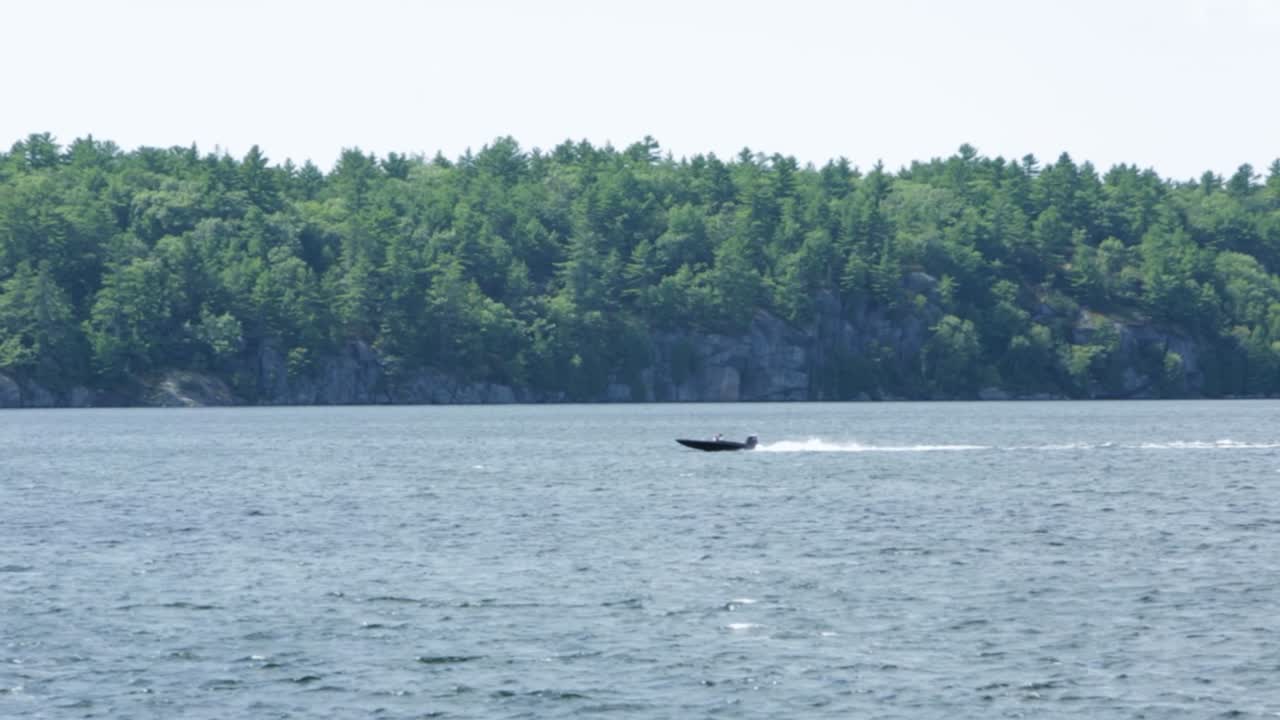 Fast Boat travelling right to left on Muskoka Lake. The camera slightly pans left, but somewhat static