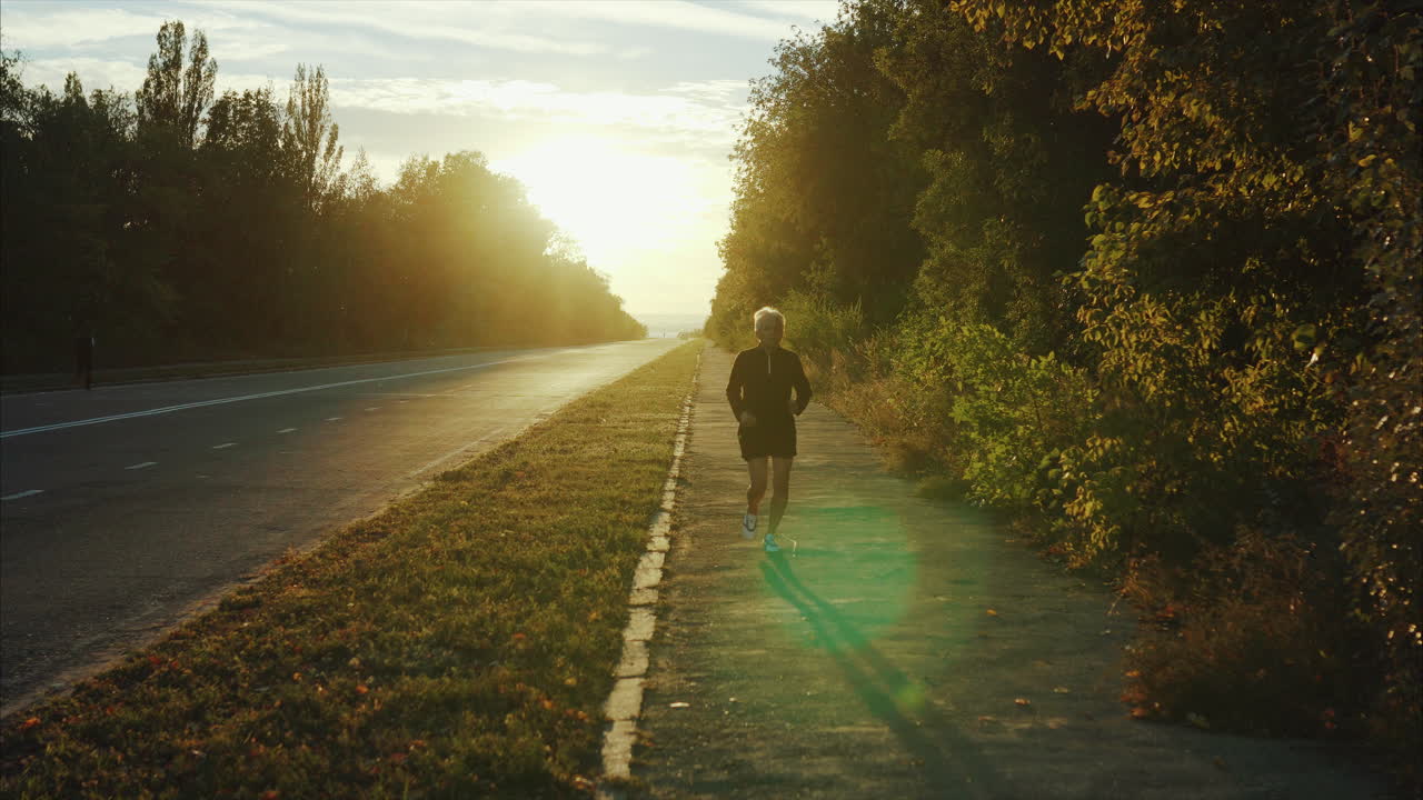 Woman Walking on a Sidewalk at Sunset