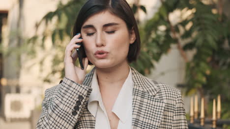 Mujer-Elegante-Haciendo-Una-Llamada-De-Negocios-Al-Aire-Libre.