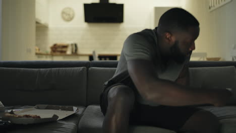 upset man taking tv remote to turn off tv in kitchen. tired man going to sleep.