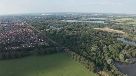 profile follow drone shot of national rail train passing through british countryside village