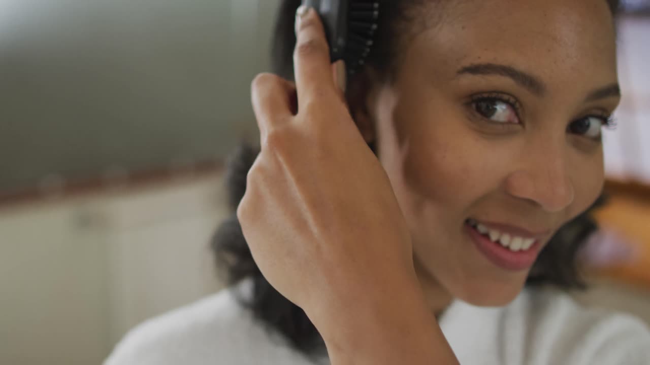 retrato de una mujer de raza mixta con bata de baño cepillando su cabello