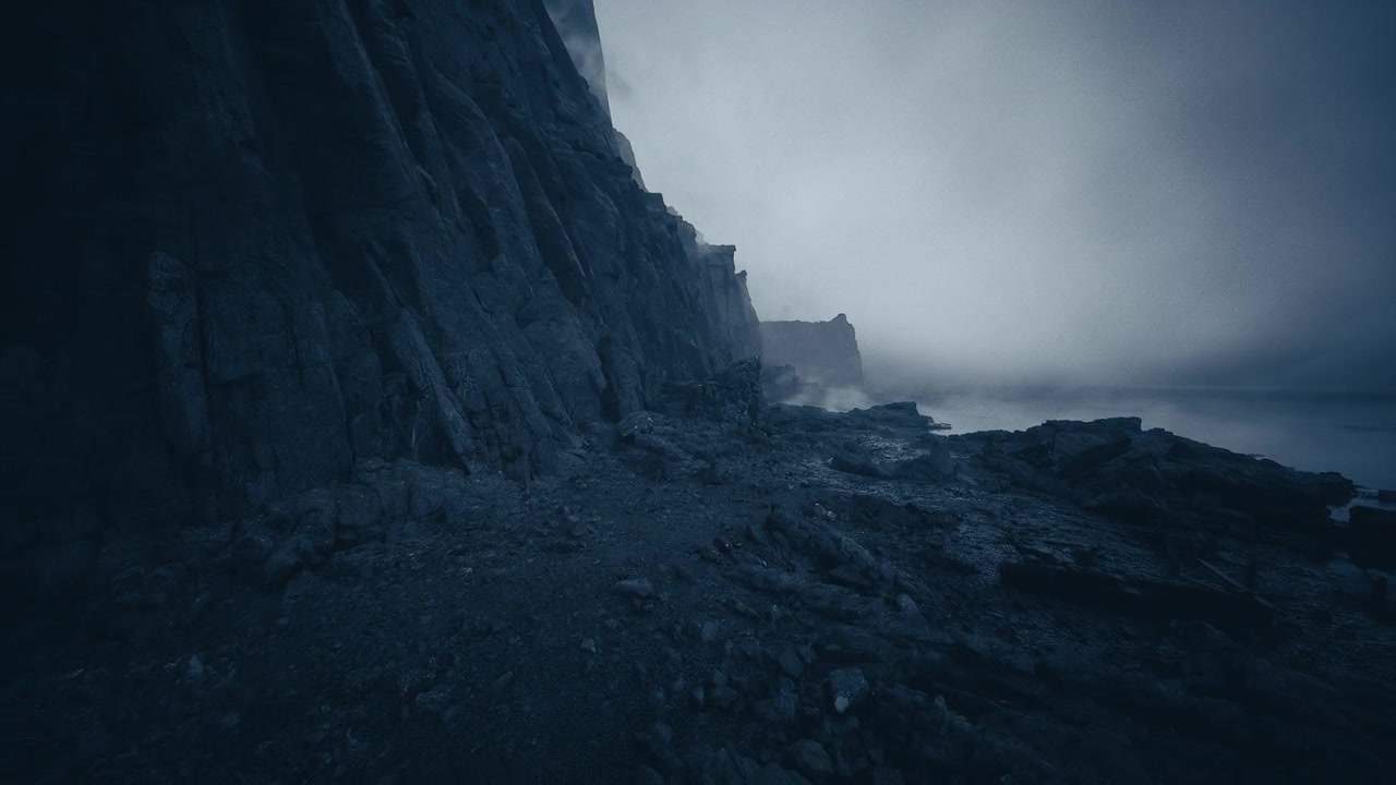 Rocas frías junto a olas rompiendo en una costa gris con madera a la deriva y acantilados.