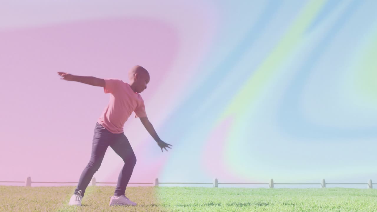 Boy shifting weight onto right foot and starting cartwheel on fenced grass lawn sports training