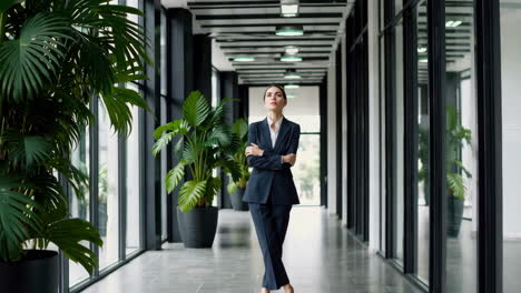 confident businesswoman standing in a modern office corridor