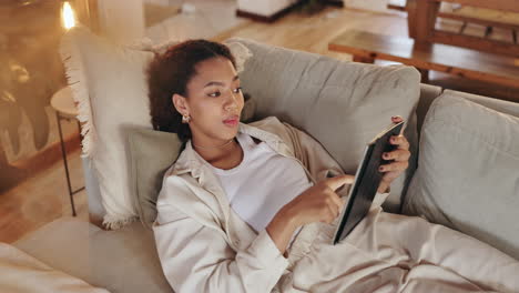 mujer relajándose en el sofá usando una tableta
