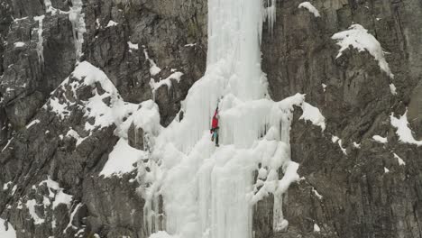 wide aerial extreme climber taking rest on frozen cascade mount kineo