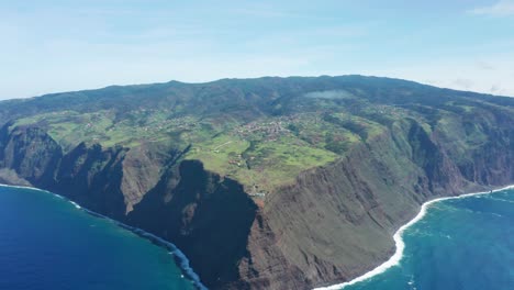 paisaje volcánico de madeira con altos acantilados rocosos rodeados de agua azul